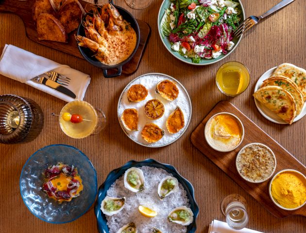 A colorful assortment of bowls with various snacks and toppings arranged on a wooden table.